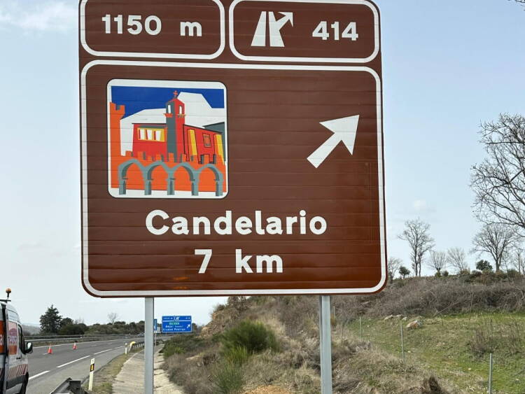 Panel turístico de Candelario instalado en la A-66 indicando el acceso al municipio a 7 kilómetros, cerca de Béjar