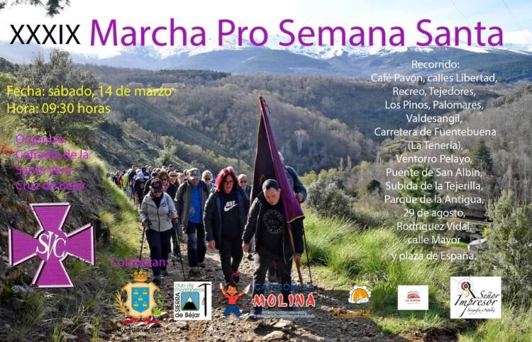 Participantes en la Marcha Pro Semana Santa de Béjar caminando por un sendero de la comarca con la sierra al fondo