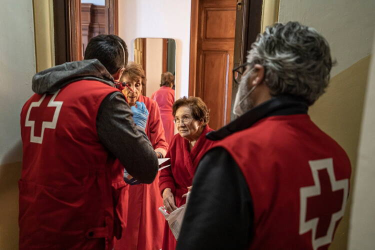 Voluntarios de Cruz Roja durante una visita a una vivienda para dar asistencia
