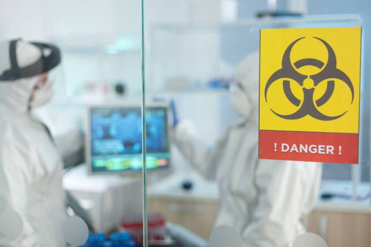 Biólogos y científicos con trajes de protección médica trabajando en un laboratorio de microbiología de un hospital.