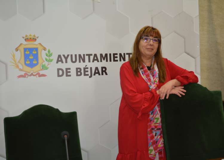 Mujer de pie, apoyada en una silla