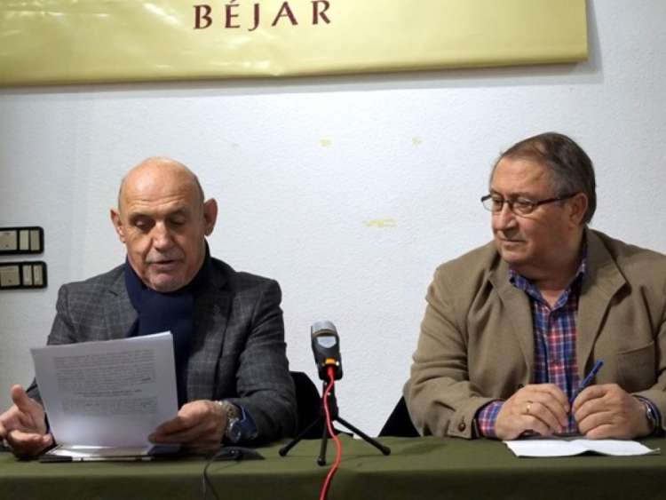 Dos hombres sentados a una mesa con papeles en mano