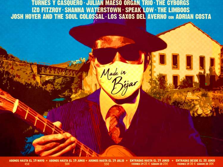 Hombre con mascarilla y guitarra con edificio museo textil de Béjar al fondo