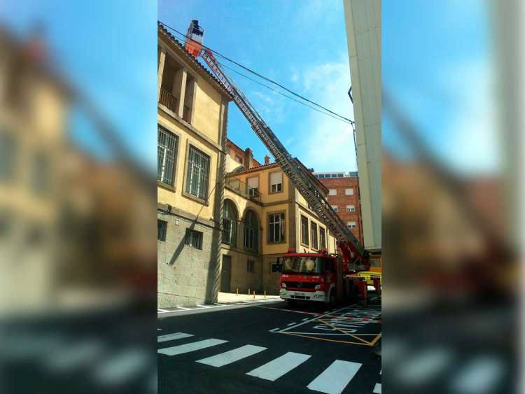 Camión escala de los bomberos trabajando en la cubierta de Correos