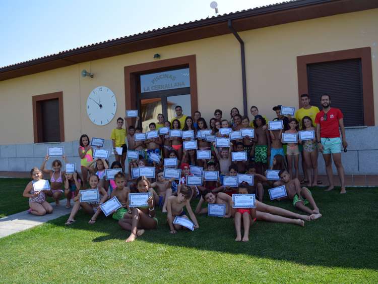 Niños y niñas de los campamentos municipales con su diploma en la piscina de La Cerrallana