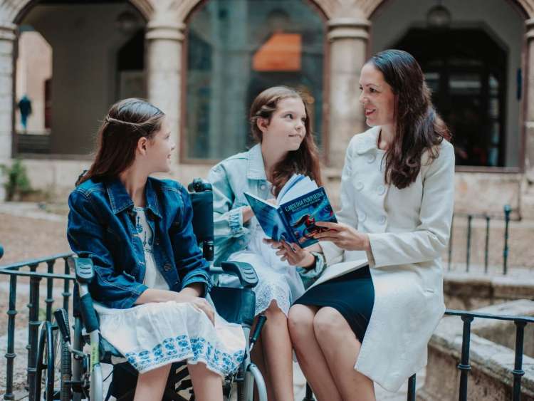 Autoras de Carolina Purpurina con el libro en un acto