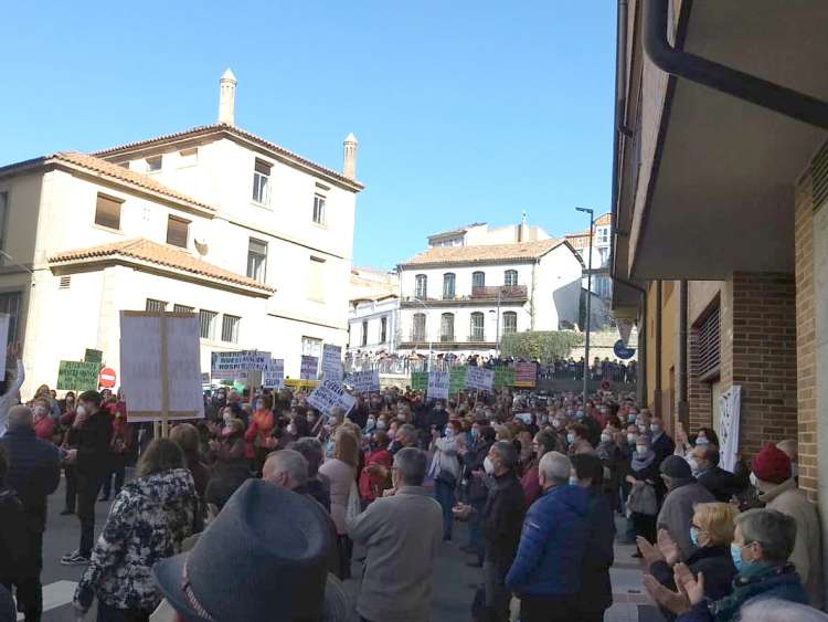 Miles de personas en la calle con pancartas frente al edificio del hospital