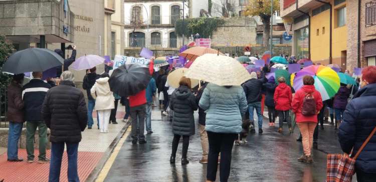 Decenas de personas de espaldas con paraguas junto al edificio del hospital de Béjar