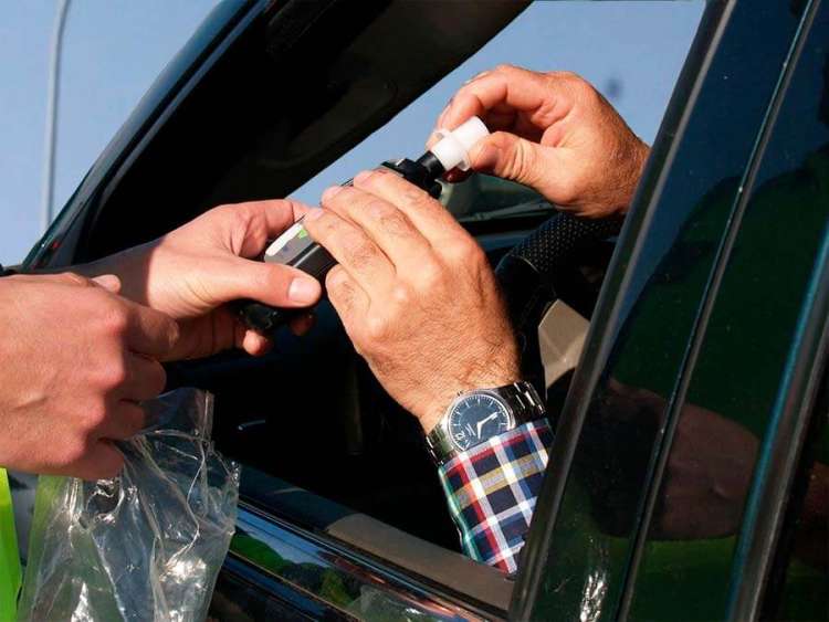 Conductor sosteniendo el alcoholimetro durante un control