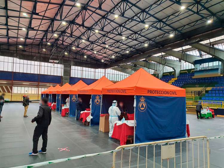 Varias carpas de protección civil instaladas dentro del pabellón y gente en ellas