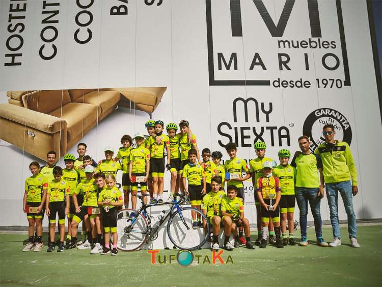 Grupo de niños, niñas y adultos junto al pódium 