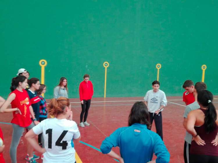Varias personas formando un corro en un pabellón deportivo