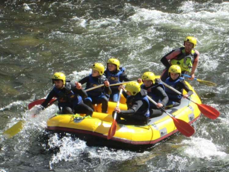 Vista parcial de uno de lso carteles promocionales, deportistas haciendo rafting