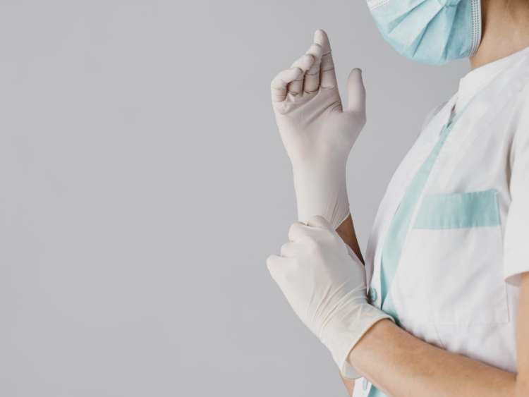 Doctor poniéndose guantes de nitrilo