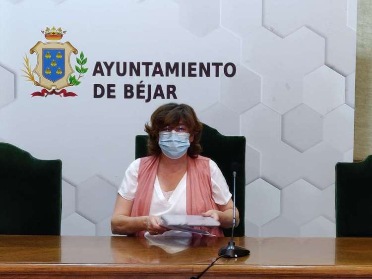 Una mujer sentada en una mesa con papeles en las mano