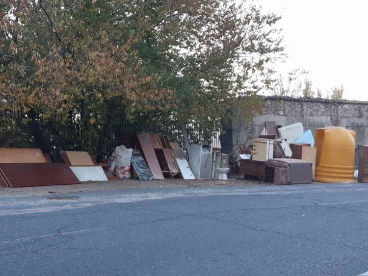 muebles viejos en calle junto a contenedor amarillo
