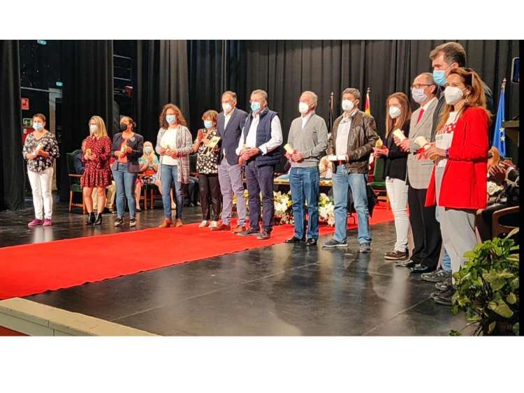 Grupo de personas sobre el escenario del teatro, cubierto parcialmente con alfombra roja