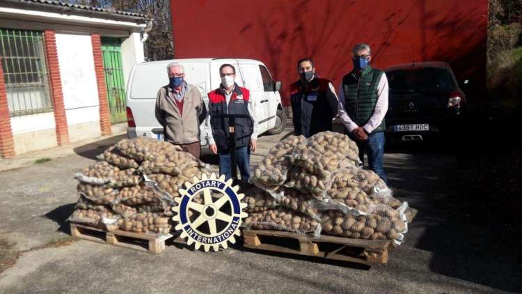 Varias personas con sacos de patatas delante