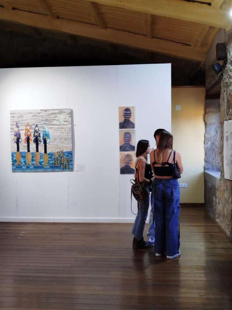 Varias personas observan obras artísticas realizadas por mujeres en el centro de arte El Bodegón de Béjar