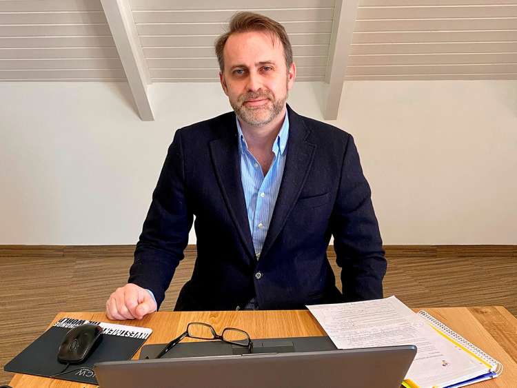 Hombre sentado en una mesa con ordenador portátil