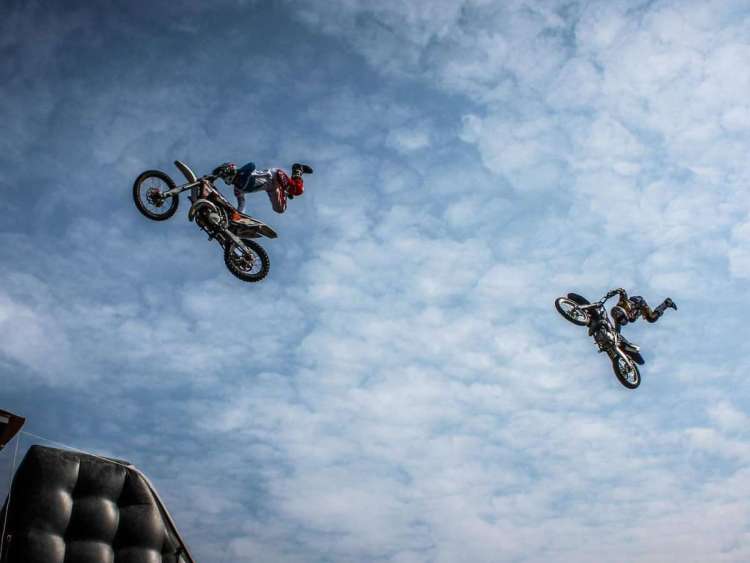 Dos pilotos realizando saltos acrobáticos con sus motos