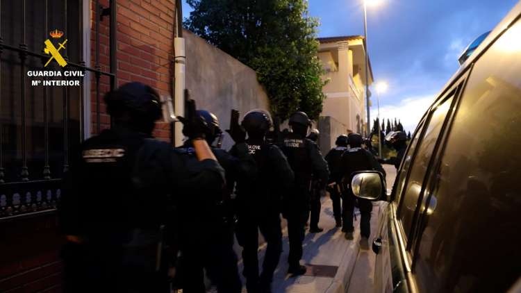 Agentes de la Guardia Civil acceden a un domicilio durante una operación contra estafas bancarias por vishing