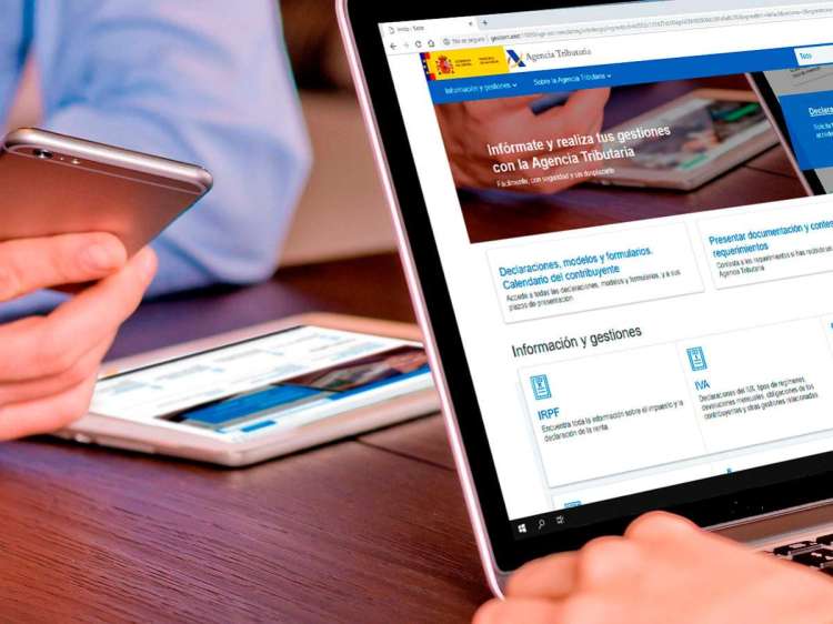 Portátil y móvil con la web de Hacienda