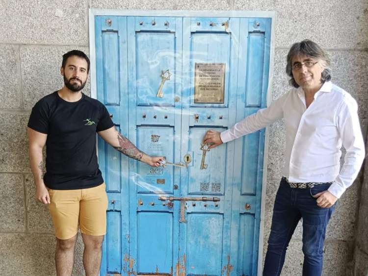 Dos personas junto a una reproducción de puerta judía en Béjar