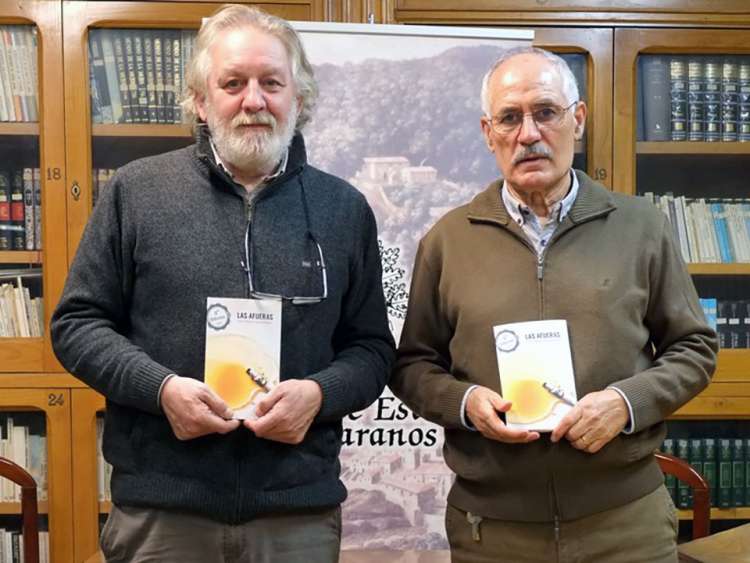 Dos personas sosteniendo un libro entre sus manos