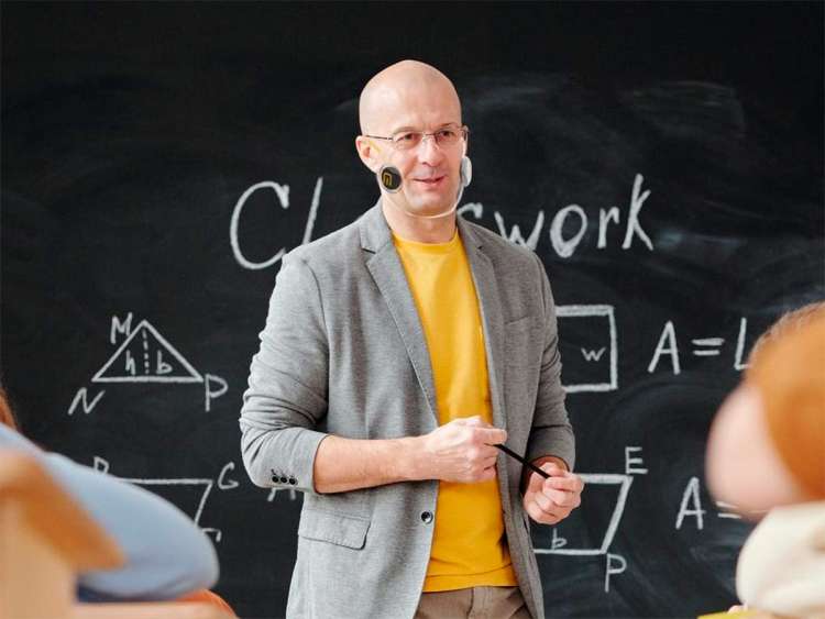 Nombre dando clase con mascarilla transparente