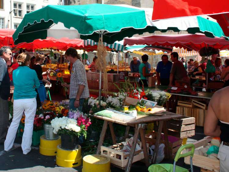 puesto mercadillo flores, fruta con varias personas