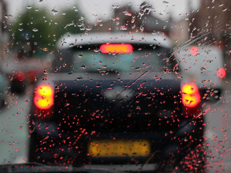 parabrisas con gotas de lluvia y coche
