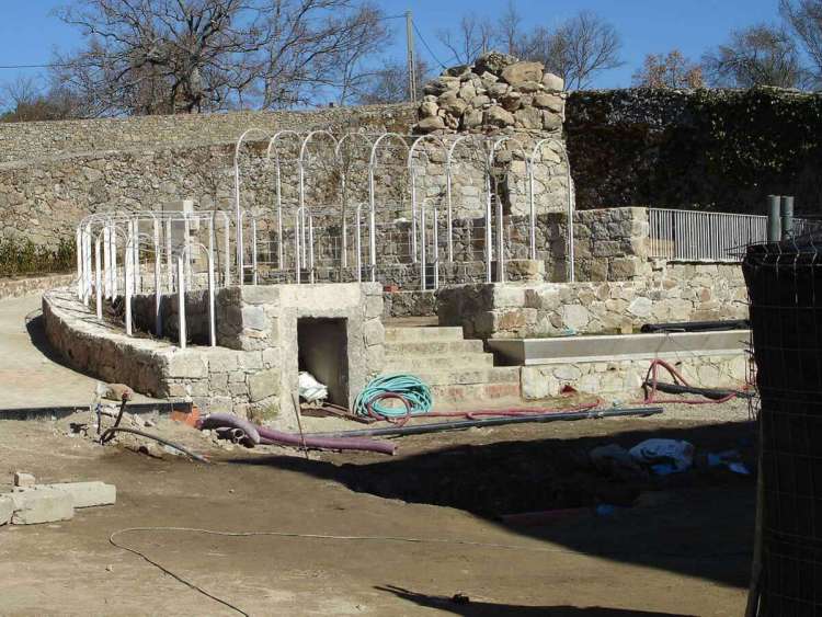 Mole de mampostería coronada de arcos y barandas metálicas en el espacio al norte del Palacete en el Bosque de Béjar