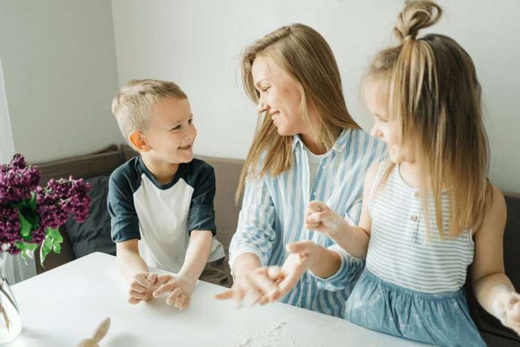 Niños junto a su madre sentados en una mesa
