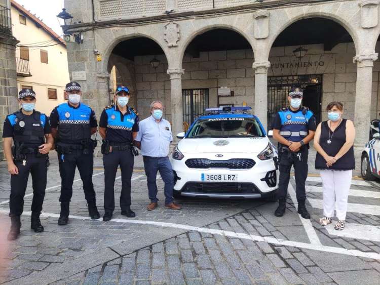 Varias personas, entre ellos 4 policías, junto al coche de policía