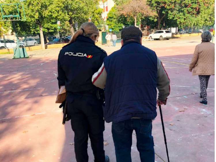 Una policía nacional acompaña a una persona mayor
