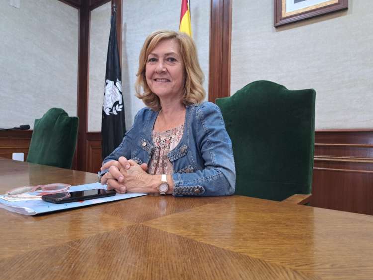 Purificación Pozo sentada tras una mesa presentando el Día del Calderillo