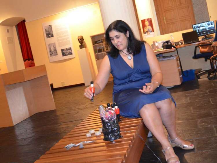 Raquel González sentada en un banco en el museo Valeriano Salas jugando con soldados de madera