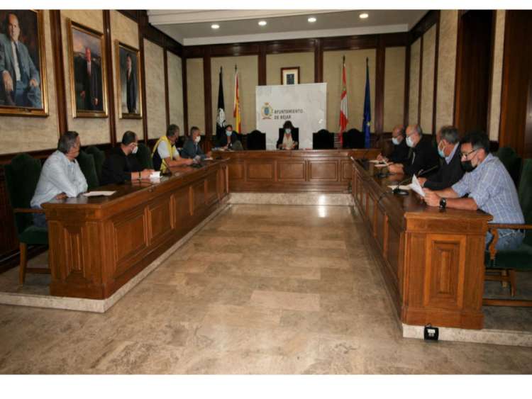 Grupo de personas sentados a una mesa con forma de U