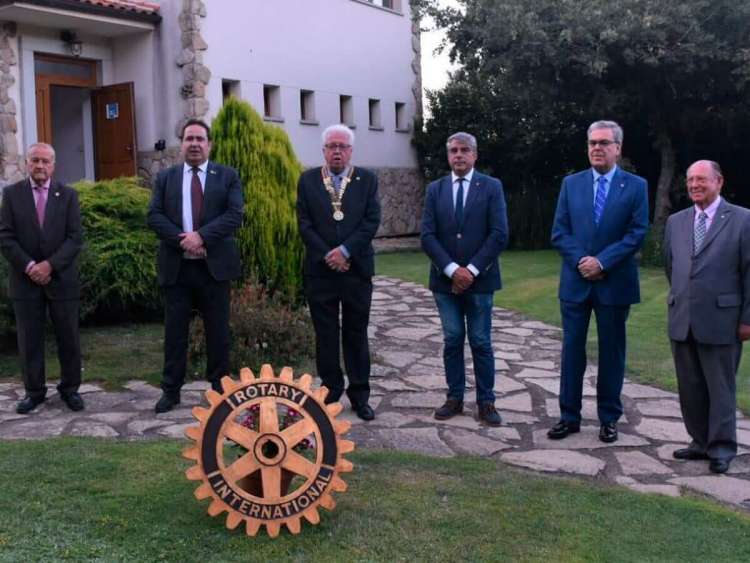 Seis personas posando tras el logotipo del rotary club