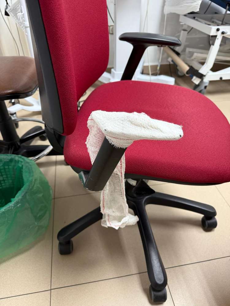 Silla con el reposabrazos roto cubierto con una venda en una consulta médica de urgencias en Béjar
