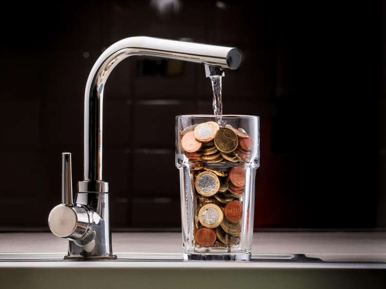 Vaso de agua lleno de monedas