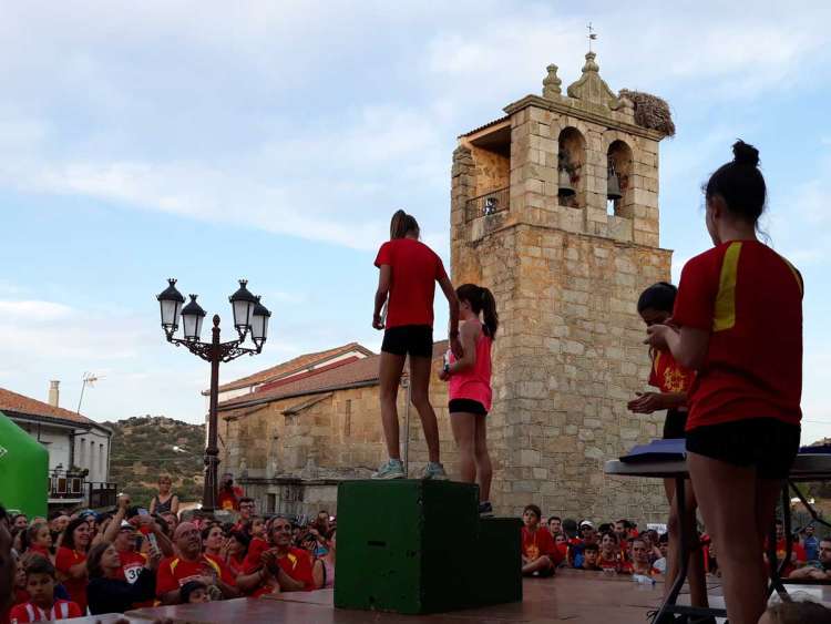 Podium en categoría femenina con la iglesia de Medinilla al fondo y numeroso público