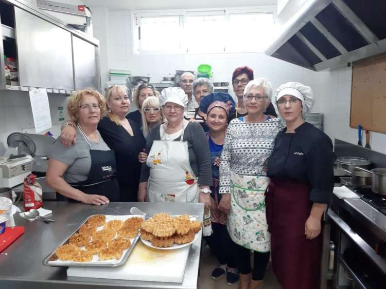 TaVarias personas en una cocina mostrando platos preparados
