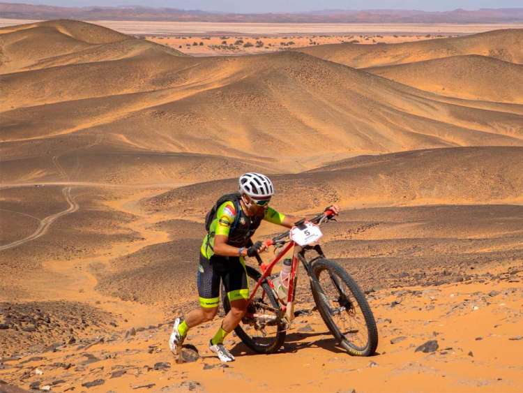 Moisés Dueñas empujando la bicicleta en la Titan Desert