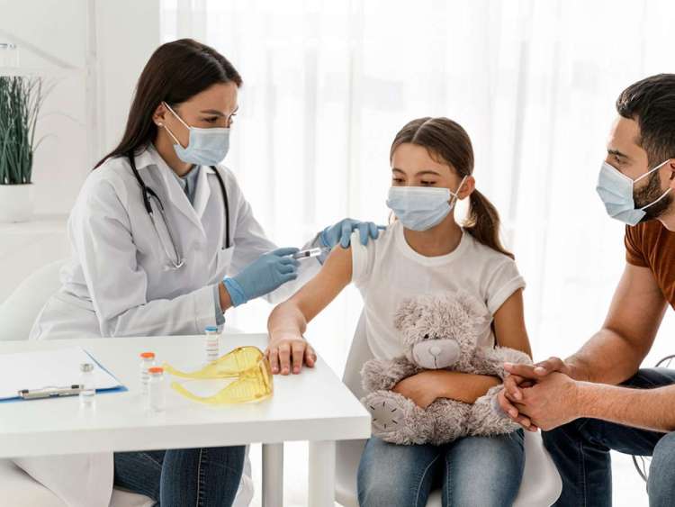 Chica vacunándose junto a su padre
