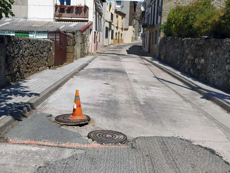 Imbornales al descubierto y asfalto sin renovar en una calle de Valdesangil