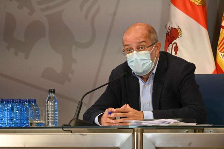 Hombre con mascarilla sentado tras una mesa