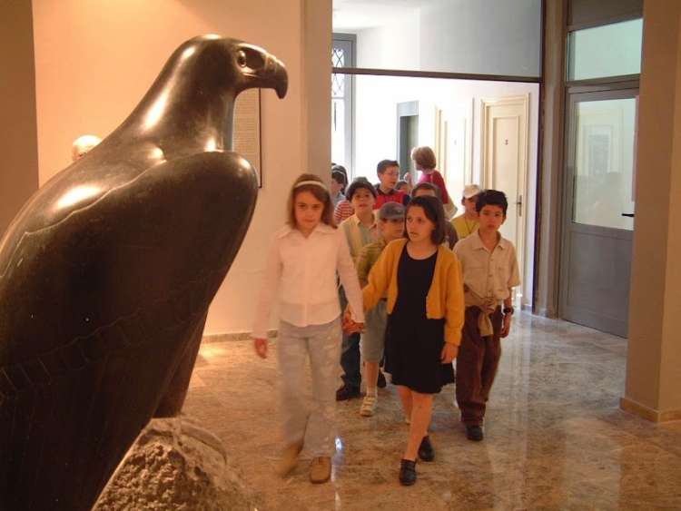Niños en el interior del museo. Escultura con forma de águila