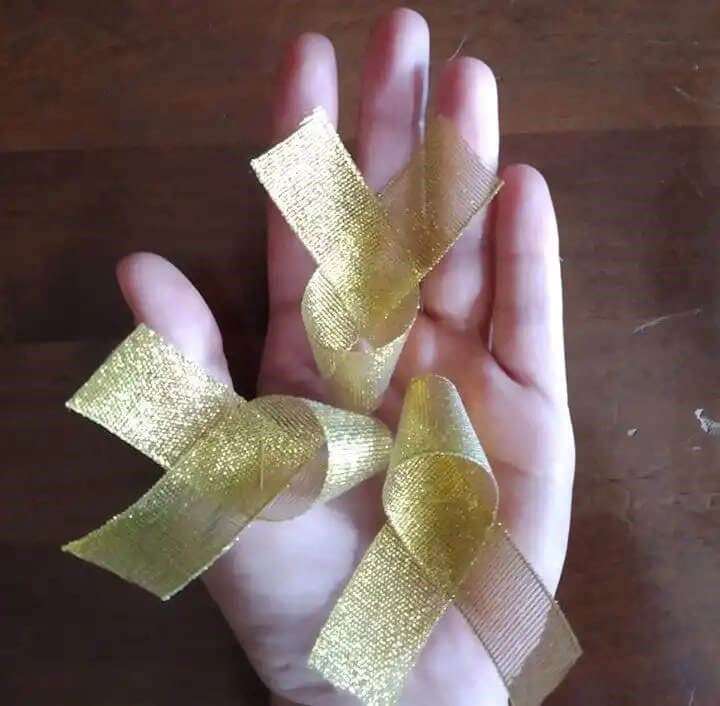 Mano sosteniendo lazos dorados